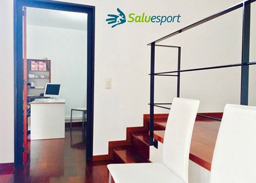 Recepción con escalera y sillas blancas