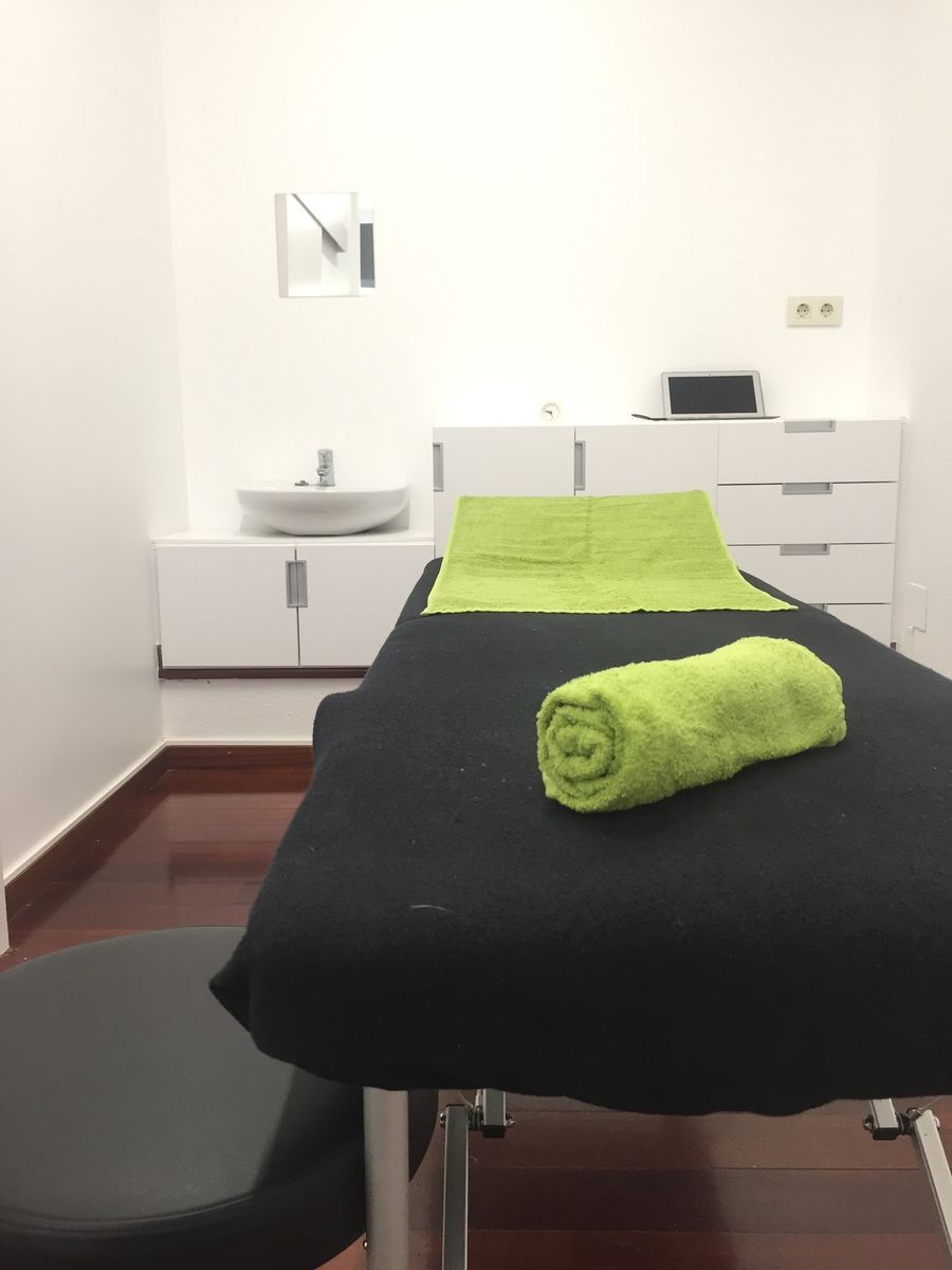 Camilla de la sala de tratamiento con toalla verde